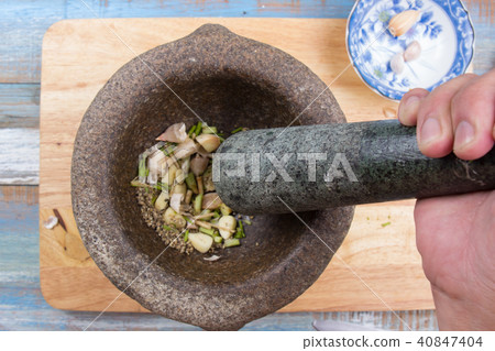Chef put coriander,pepper and garlic to mortar 40847404