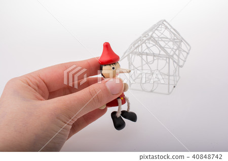 Hand holding pinocchio beside a model house 40848742