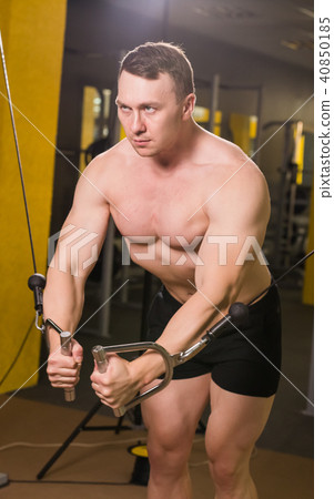 Strong muscular bodybuilder doing exercise in the gym. Fitness training Strong muscular bodybuilder doing exercise in the gym. Fitness training 40850185