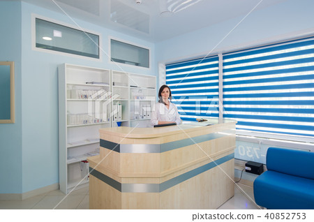 friendly young woman behind the reception desk administrator 40852753