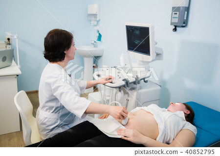 Pregnant woman doing ultrasound scan in the prenatal clinic, mother worried about health of her 40852795