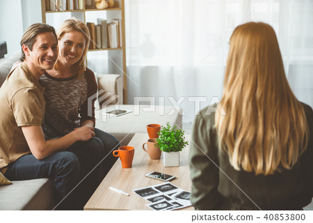 Excited childless family talking about surrogacy with pregnant woman  40853800