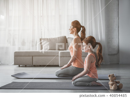 Woman and her child are meditating at home 40854485
