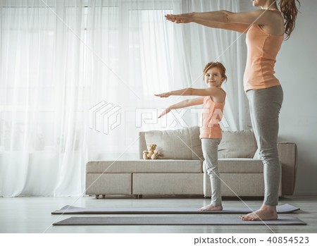 Little girl doing fitness exercise with mother at home 40854523
