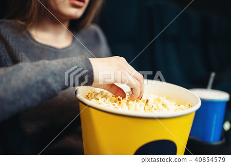 Woman eats popcorn while watching movie in cinema 40854579