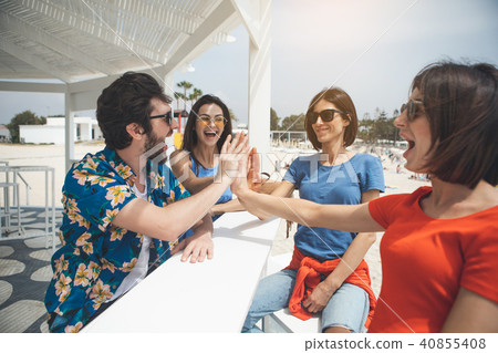 Joyful young man and women having fun at the beach Joyful young man and women having fun at the beach 40855408