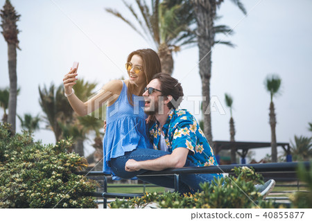 Cheerful guy and girl taking photo in nature Cheerful guy and girl taking photo in nature 40855877