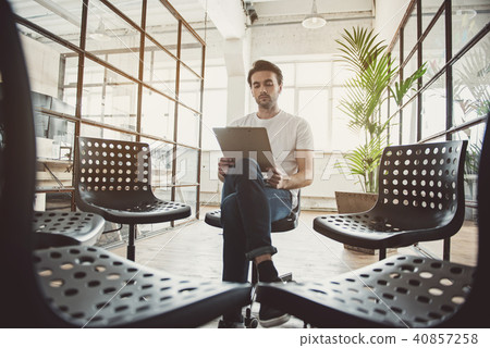 Calm male looking through information on clipboard 40857258
