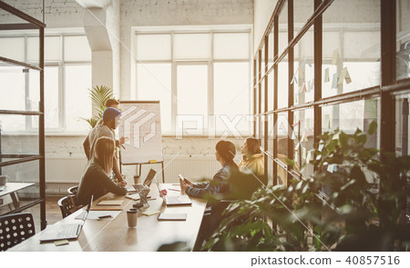 Satisfied partners watching at board in office 40857516