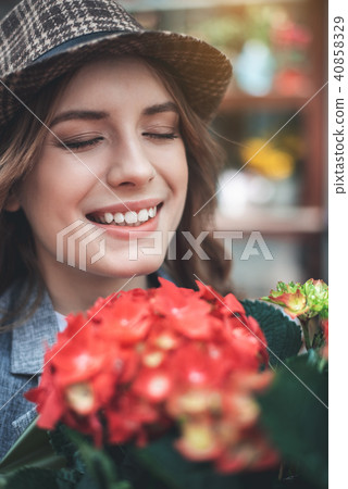 Cheerful young woman with red flowers 40858329