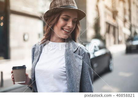 Cheerful lady with cup of coffee outside Cheerful lady with cup of coffee outside 40858821