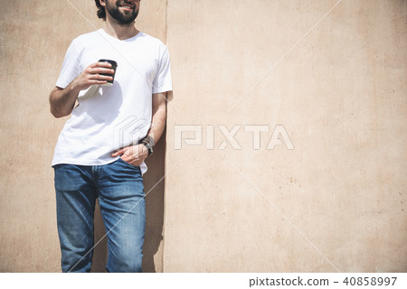 Glad guy enjoying hot drink on the street 40858997