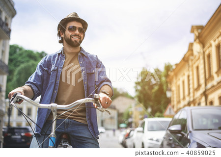Happy guy in hat riding bicycle 40859025