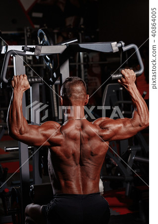 Chest press. Handsome muscular sexy man in gym doing exercises. Tanned athlete. Chest workouts. Chest press. Handsome muscular sexy man in gym doing exercises. Tanned athlete. Chest workouts. 40864005