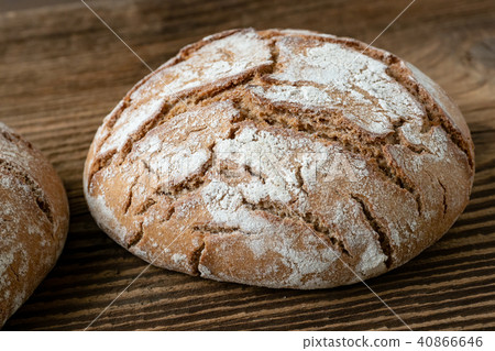 Delicious baked bread on a wooden background 40866646