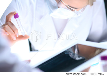 Closeup of scientific research team with clear solution in laboratory. Blonde female chemist holds 40867967