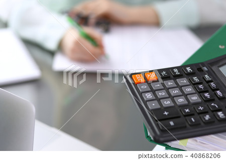 Bookkeeper or financial inspector  making report, calculating or checking balance. Binders wit 40868206