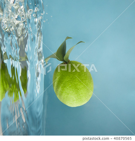 Round green lime with leaves in water on a blue background Round green lime with leaves in water on a blue background 40870565