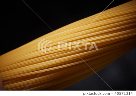 Macro photo of a yellow spaghetti on a black background Macro photo of a yellow spaghetti on a black background 40871314