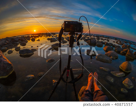 Photographer taking pictures of beautiful sunset at sea side Photographer taking pictures of beautiful sunset at sea side 40871557