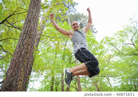 Athletic man jumping in forest 40871651