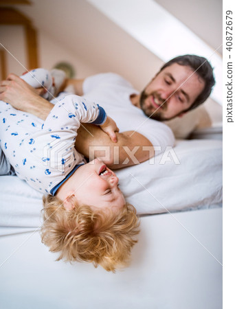 Father with a toddler boy having fun in bedroom at home at bedtime. 40872679