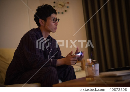 一個年輕的日本男性從事遊戲與睡衣 一個年輕的日本男性從事遊戲與睡衣 40872808