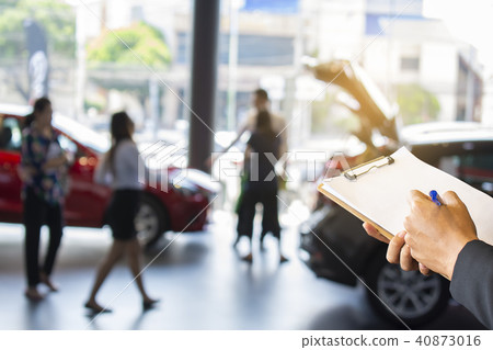 Business man writing of notepad on car showroom 40873016