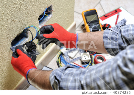 Electrician at work with safety equipment Electrician at work with safety equipment 40874285