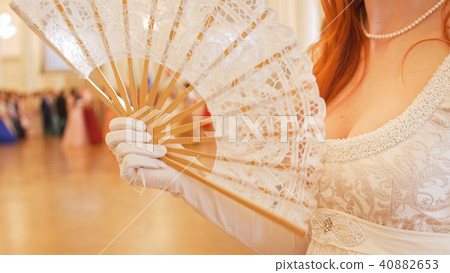 Beautiful woman in vintage ball costume woman waving a fan Beautiful woman in vintage ball costume woman waving a fan 40882653