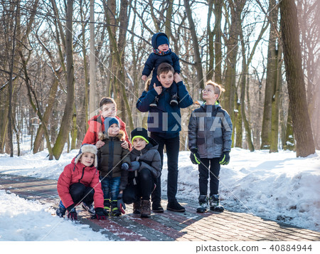 Group of little boys posing for camera in winter park Group of little boys posing for camera in winter park 40884944