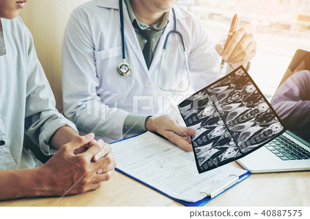 Doctor consulting with patient presenting Doctor consulting with patient presenting 40887575