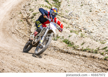 Professional Motocross Motorcycle Rider Drives Over the Road Track. Professional Motocross Motorcycle Rider Drives Over the Road Track. 40887972