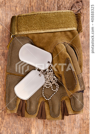 Dog tags on military fingerless glove. 40888325