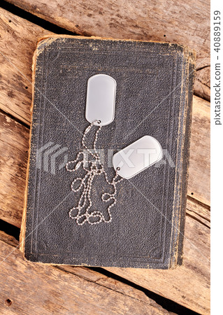 Old book and dog tags. Old book and dog tags. 40889159