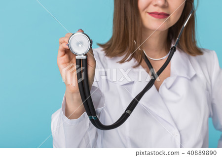 Doctor with stethoscope, close up over blue background Doctor with stethoscope, close up over blue background 40889890