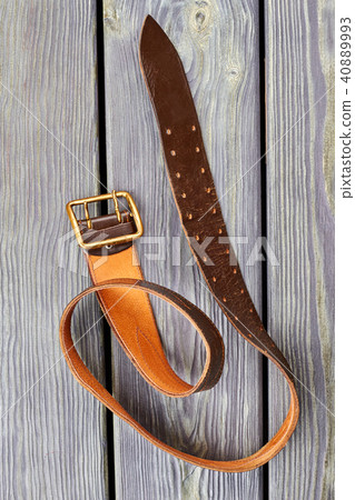 Twisted orange belt on wood. Twisted orange belt on wood. 40889993