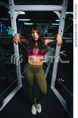 Woman standing in gym background 40891582