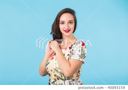 Confident girl smiling to camera. Portrait of woman over blue background Confident girl smiling to camera. Portrait of woman over blue background 40893159
