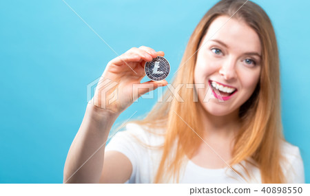 Woman holding a physical Litecoin 40898550