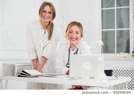 Two Female friendly cheerful Doctors or Nurses Isolated in office smiling and looking at camera 40899094