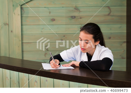 The female doctor sits at a table having closed eyes for fatigue 40899473