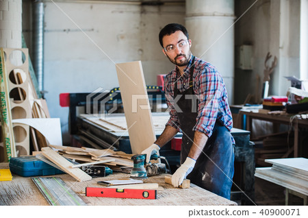 Worker grinds the wood of angular grinding machine 40900071