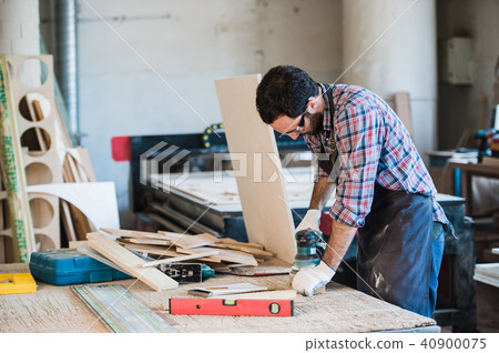 Carpenter with power grinder at his workshop Carpenter with power grinder at his workshop 40900075
