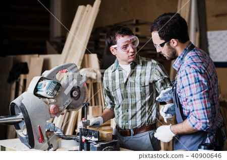 Two men builder with circular saw having a conversation 40900646