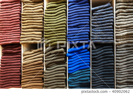 Wooden shelves with stack of different color socks 40902062