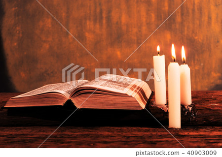 Bible and candle on a old oak wooden table. Bible and candle on a old oak wooden table. 40903009