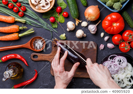 Photo on top of fresh vegetables, champignons, cutting board, oil, knife, eggplant, chef's hands Photo on top of fresh vegetables, champignons, cutting board, oil, knife, eggplant, chef's hands 40905920