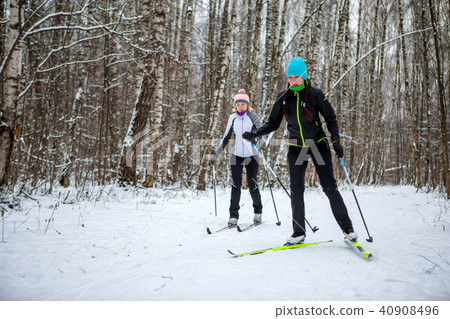 Picture of sports women and men skiing in winter forest 40908496
