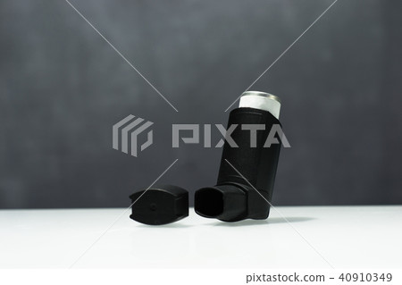 Black Asthma inhaler on a white table. Black Asthma inhaler on a white table. 40910349